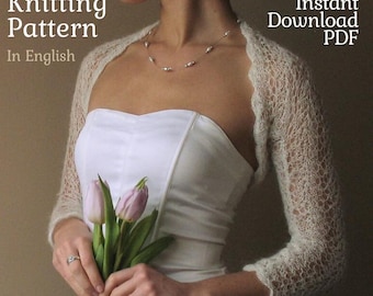 May include: A woman wearing a cream-colored, open-weave knitted shrug over a white strapless dress. The image includes the text "Knitting Pattern In English" and "Instant Download PDF". The woman is holding a bouquet of pink tulips.