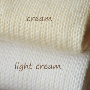 Puede incluir: Dos muestras de tejido de punto, una en crema y otra en crema claro.