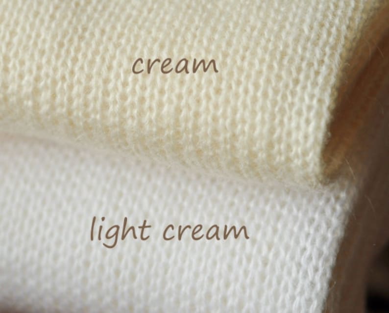 Puede incluir: Dos muestras de tejido de punto, una en crema y otra en crema claro.