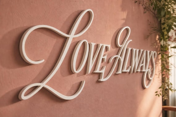Vowline Raised Letter Set spelling Love Always on a wedding photo backdrop from a distinct close viewpoint.