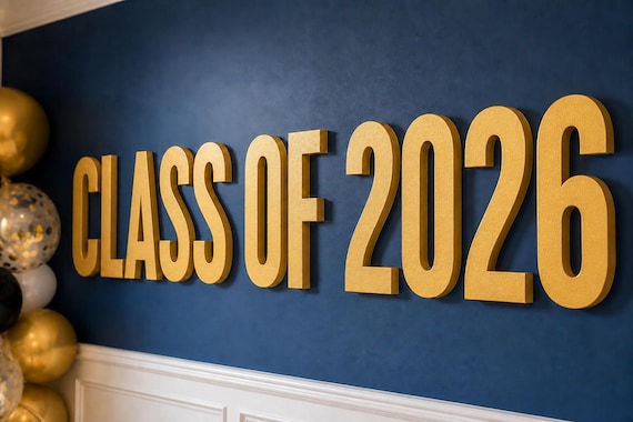 Vowline Raised Letter Set spelling Class of 2026 in gold on a graduation-party wall, shown close up.