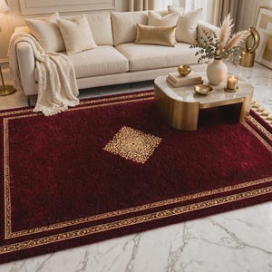 Puede incluir: Una alfombra rectangular de color rojo intenso con un patrón central de rombos dorados y un borde a juego. La alfombra está rematada con borlas de color crema en dos lados opuestos, lo que aporta una textura distintiva al suelo.