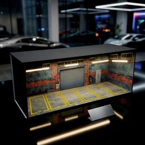 May include: A miniature garage diorama with a brick and concrete facade. The garage features a roll-up door, parking lines, and a small door. The scene is illuminated by overhead lights, creating a realistic setting.