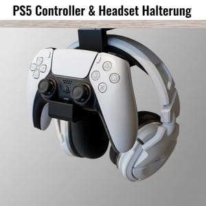 May include: A white PS5 controller and headset hanging from a black holder. The controller has black joysticks and buttons. The headset is white and gray. The text "PS5 Controller & Headset Halterung" is at the top.