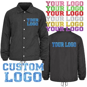 May include: Black coach jacket with the text "YOUR LOGO" on the front and back. The jacket has a drawstring at the bottom and white snap closures. The words "CUSTOM LOGO" are also displayed in a blue, textured font.