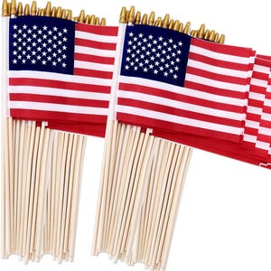May include: Miniature American flags with red and white stripes and a blue field of white stars. The flags are attached to wooden dowels with gold-colored finials. A patriotic symbol.