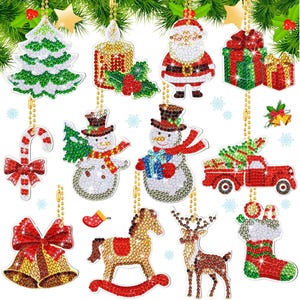 May include: A collection of Christmas ornaments in various shapes, including a Christmas tree, Santa Claus, a snowman, a candy cane, and a reindeer. The ornaments are decorated with colorful gems and hanging from gold chains.