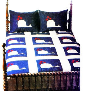 May include: A blue and white quilt with a whale design and red hearts. The quilt is on a wooden bed frame with a headboard and footboard. There are two matching pillowcases with the same whale design.