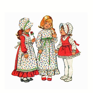 May include: Three girls wearing vintage-style dresses and hats. The girls are wearing red and white dresses with floral patterns. The dresses have ruffled hems and the girls are wearing white tights and shoes.