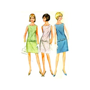 May include: Three sleeveless dresses in different patterns and colors. The dress on the left is green and white plaid, the middle dress is white with pink flowers, and the dress on the right is blue.