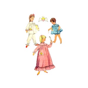 May include: Three girls wearing different nightgowns with angel motifs. The girl in the center is holding a mirror and looking at herself. The girl on the left is holding a book. The girl on the right is wearing a blue nightgown with a white trim.