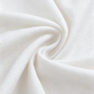 May include: Close-up of a white fabric with soft folds and a textured surface. The fabric appears to be tightly woven, with a subtle sheen. The image highlights the fabric's smooth texture and bright white color.