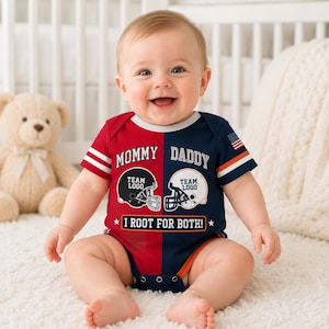 Puede incluir: Un body de bebé de manga corta con un diseño dividido en rojo y azul marino. La parte delantera muestra el texto MOMMY y DADDY sobre dos gráficos de cascos de fútbol americano con el texto TEAM LOGO y la frase I ROOT FOR BOTH! abajo.