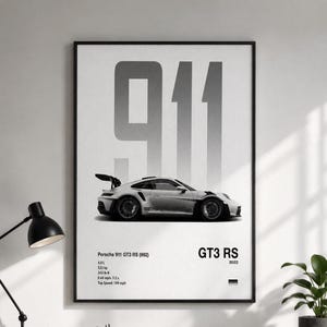 Puede incluir: Un póster de pared enmarcado que muestra el perfil lateral de un Porsche 911 GT3 RS (992) blanco. El texto grande 911 aparece en gris sobre el coche. Las especificaciones técnicas incluyen 4.0 L, 525 hp, 343 lb-ft, 0-60 mph: 3.2 s y 184 mph.
