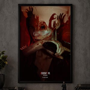 May include: A framed rectangular poster featuring a dark, atmospheric illustration of a person with blood-like red splatters and clawed hands reaching from their head. The text reads RESIDENT EVIL, Veronica, and CAPCOM in white and red lettering.