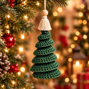 May include: A dark green crocheted Christmas tree ornament featuring a tiered, spiral design. The top of the ornament is adorned with a light-colored wooden bead and a cream-colored macrame tassel, suspended by a thin, natural-colored twine loop.