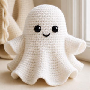 May include: A white crocheted ghost figure with a rounded head and flared base. The ghost features two round, glossy black plastic safety eyes and a small, simple black embroidered mouth, creating a friendly expression on the textured yarn surface.