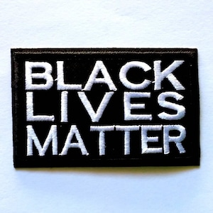 Può includere: Toppa ricamata "Black Lives Matter" su sfondo nero con lettere bianche.