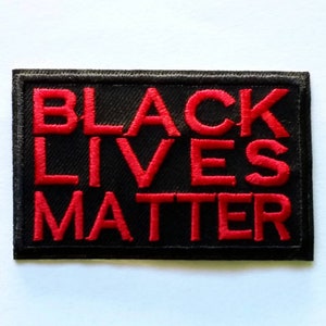 May include: Black Lives Matter embroidered patch with red lettering on a black background.