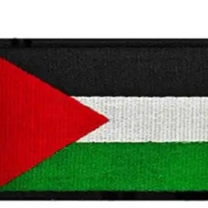 Op de afbeelding: Een geborduurde patch met de Palestijnse vlag. De patch is zwart, wit en groen met een rode driehoek in de linkerbovenhoek.
