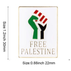 May include: Rectangular pin with a white background and a gold border. The pin features a green fist with red and black accents, and the words "FREE PALESTINE" in black. The pin measures 1.2 inches by 0.88 inches.
