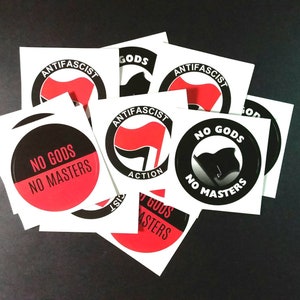 May include: A set of eight black and red round stickers with the text "No Gods No Masters" and an image of a black flag. Some stickers also have the text "Anti-Fascist" and an image of a red flag.
