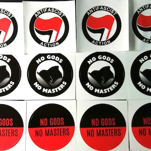 May include: A collection of stickers with anti-fascist and anarchist slogans. The stickers feature a red flag in a black circle with the words "ANTIFASCIST ACTION". Other stickers say "NO GODS NO MASTERS" in a circle.