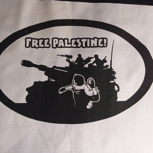 May include: Black and white illustration of a tank with soldiers on top. The tank is in an oval shape with the text "FREE PALESTINE!" above it.