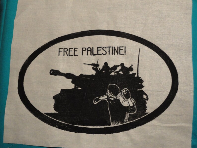 May include: A black and white image of a tank with soldiers on top. The tank is in a circle with the text "FREE PALESTINE!" above it.