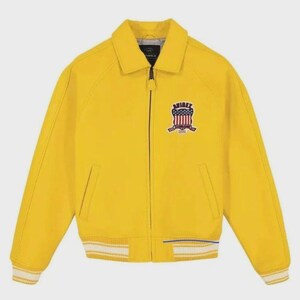 May include: A bright yellow jacket with a zipper closure, a collar, and a patch on the chest. The jacket has white and blue striped cuffs and hem. The patch features a shield design with red, white, and blue elements.