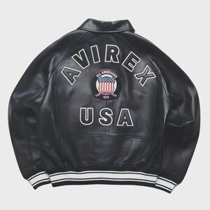 May include: Black leather jacket with the word "AVIREX" arched across the upper back in white lettering. Below the word "AVIREX" is a circular patch with the words "ALL AMERICANS" and "1975" and a design of the American flag. The word "USA" is below the patch. The jacket has white stripes on the cuffs and hem.