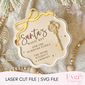 May include: A wooden sign with the text "Santa's Magic Key" and a decorative gold key. The sign is shaped like a scalloped edge and has a gold bow accent. The text "For the Hurhome Family" is also included.