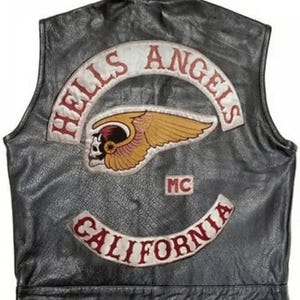 May include: A black leather vest featuring a large embroidered patch on the back. The patch displays the text HELLS ANGELS in red, a winged skull emblem in gold and red, the letters MC, and the text CALIFORNIA in red on a curved white background.