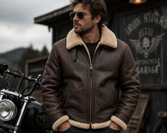 May include: A dark brown leather jacket with a thick beige shearling collar and cuffs. The jacket features a central brass-colored zipper, a smooth leather exterior with a distressed finish, and a soft, light-colored fleece lining visible at the edges.