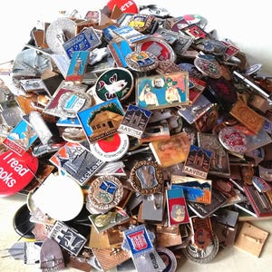 Sacchetto a sorpresa contenente 50 vecchie spille assortite di varie città, sport e spazio.
