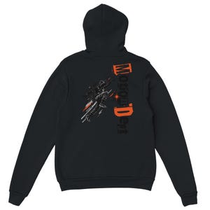 Puede incluir: Una sudadera con capucha negra que presenta un gráfico en la espalda de una persona en movimiento con líneas de velocidad naranjas y blancas. El texto "Motion Dept" está impreso verticalmente en letras naranjas y negras junto a la figura.