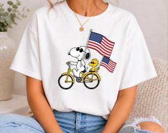 Snoopy e Woodstock in bicicletta con bandiere americane (Download immediato in formato PNG)