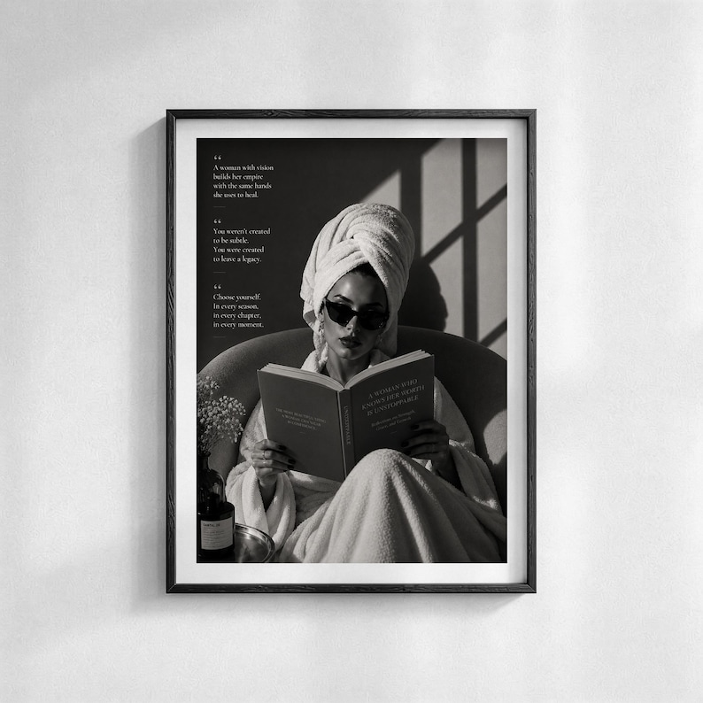 Puede incluir: Impresi&oacute;n en blanco y negro enmarcada que muestra a una persona con gafas de sol y una toalla leyendo un libro. Texto a la izquierda, botella y cuenco sobre una mesa.