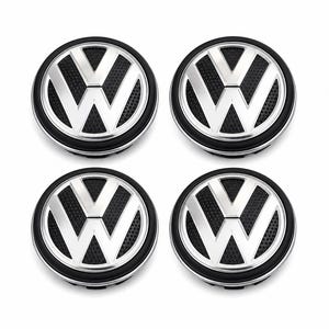Könnte beinhalten: Vier schwarze und silberne Radkappen mit dem Volkswagen-Logo. Die Radkappen haben eine schwarze, strukturierte Mitte mit einem silbernen VW-Emblem und einem schwarzen Außenring. Die Radkappen sind rund und werden auf weißem Hintergrund gezeigt.