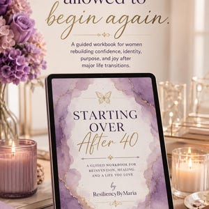 Könnte beinhalten: Ein Tablet zeigt das Cover eines Arbeitsbuchs mit dem Titel "Starting Over After 40". Das Cover zeigt Aquarellkunst in Lila- und Goldtönen. Der Text "You are allowed to begin again" steht über dem Tablet. Kerzen und Blumen sind im Hintergrund.