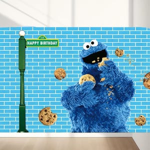 May include: A blue furry character, holding and eating chocolate chip cookies, stands in front of a blue brick wall. A green street sign reads "HAPPY BIRTHDAY". Several cookies are scattered around the character.