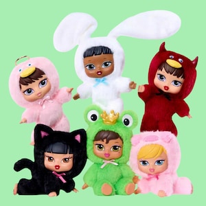 Peut inclure: Six poupées Bratz vêtues de costumes d'animaux en peluche : un canard rose, un lapin blanc, un diable rouge, un chat noir, une grenouille verte et un ours rose. Chaque poupée a de grands yeux, des lèvres pleines, sur fond vert clair.