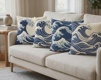 Pode incluir: Quatro almofadas com um padrão de ondas azul marinho e creme estão dispostas num sofá bege. As almofadas apresentam uma representação estilizada das ondas do oceano, evocando uma estética costeira ou náutica. O sofá está numa sala de estar.