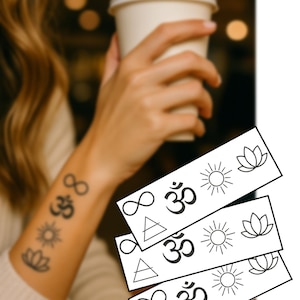 Puede incluir: Tatuajes temporales negros con símbolos espirituales como el símbolo del infinito, Om, el sol, la flor de loto y un triángulo. Los tatuajes se muestran en un brazo y en tarjetas separadas.
