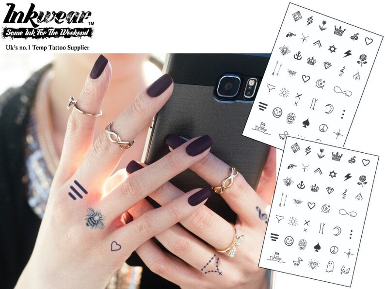 May include: Two sheets of temporary tattoos with a variety of small black and white designs, including hearts, stars, anchors, and musical notes. The sheets are on a white background. The text "Inkwear Some Ink For The Weekend" is at the top of the image.