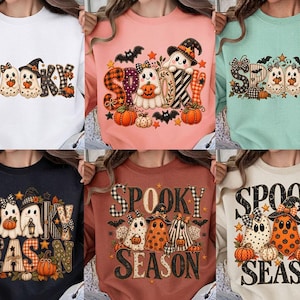 Puede incluir: Una colección de seis sudaderas de cuello redondo en blanco, melocotón, verde menta, negro, óxido y crema. Cada una presenta un estampado gráfico con el texto "SPOOKY" o "SPOOKY SEASON" junto a ilustraciones de fantasmas, calabazas y murciélagos.
