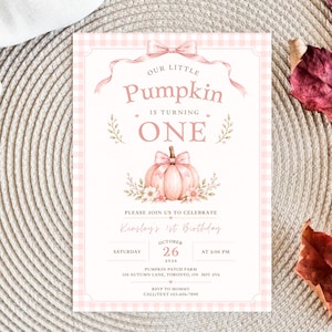 May include: A rectangular birthday invitation card with a light pink gingham border. The text reads: Our Little Pumpkin Is Turning One, Kinsley's 1st Birthday, Saturday October 26 2026 at 2:00 PM, Pumpkin Patch Farm, 158 Autumn Lane, Toronto, ON M5V 2V6.
