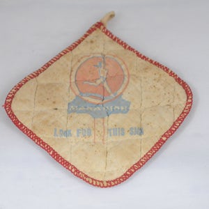 May include: A quilted, beige pot holder with red stitching. It features a blue and red logo with a woman running and the text "Marathon! Look for this sign."