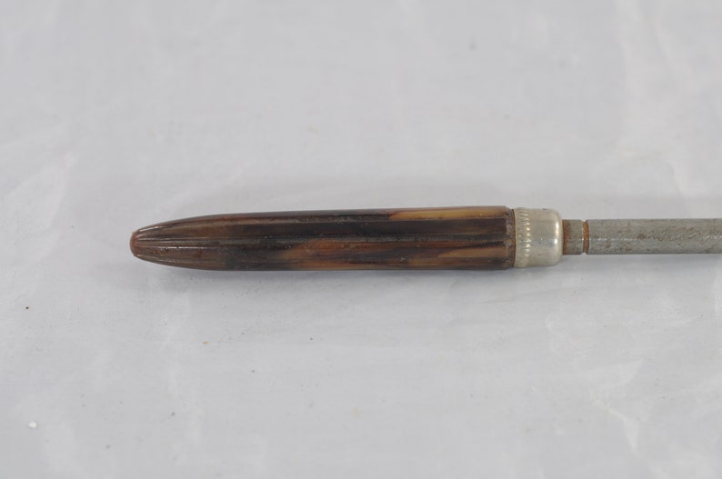 May include: A brown and silver screwdriver with a wooden handle.
