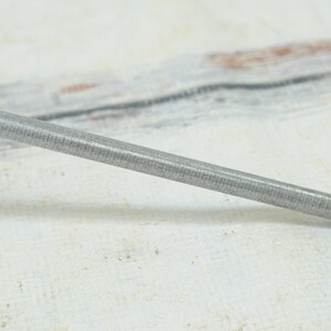 May include: A silver metal sharpening steel with a textured surface.
